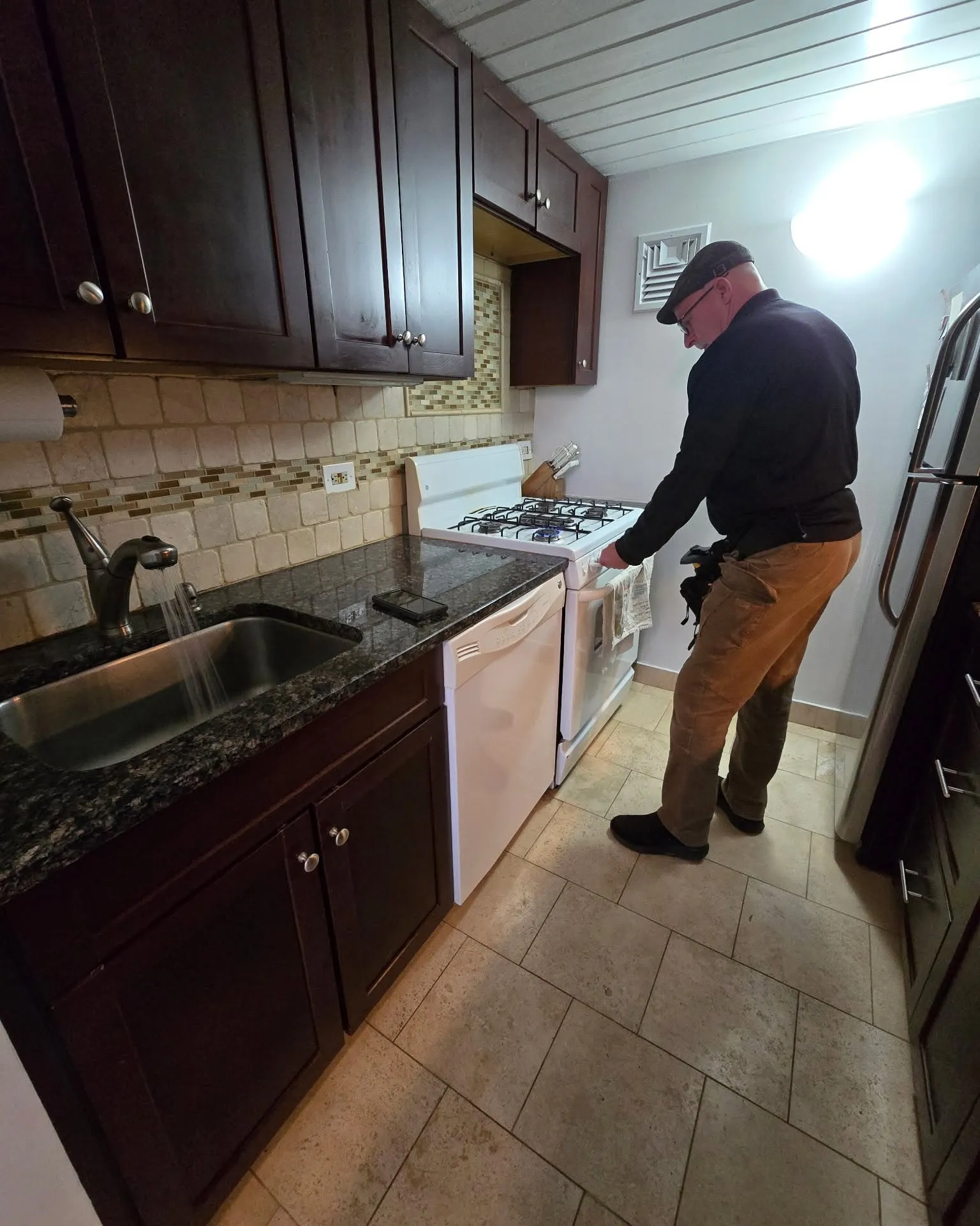 Eagle Eye inspector Lance Kotash checking a gas range in a kitchen