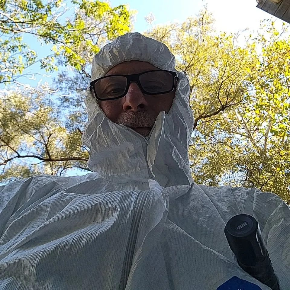 Eagle Eye inspector Lance Kotash wearing a white protective hood and glasses outdoors
