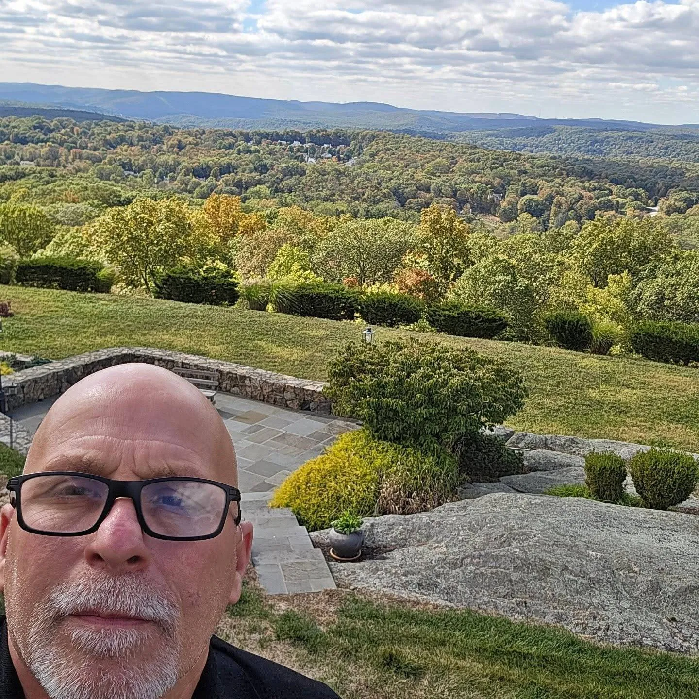 Eagle Eye inspector Lance Kotash on a hilltop property overlooking wooded hills